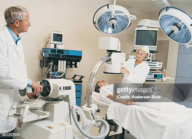 nurse positions medical scanner over patient - man lying on operating table stock pictures, royalty-free photos & images