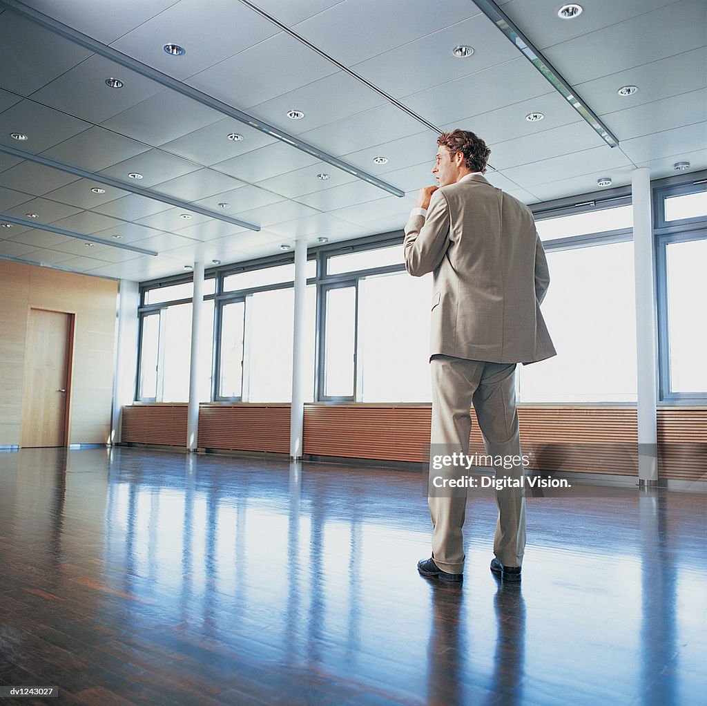 Businessman Standing in an Office With His Hand on  His Chin