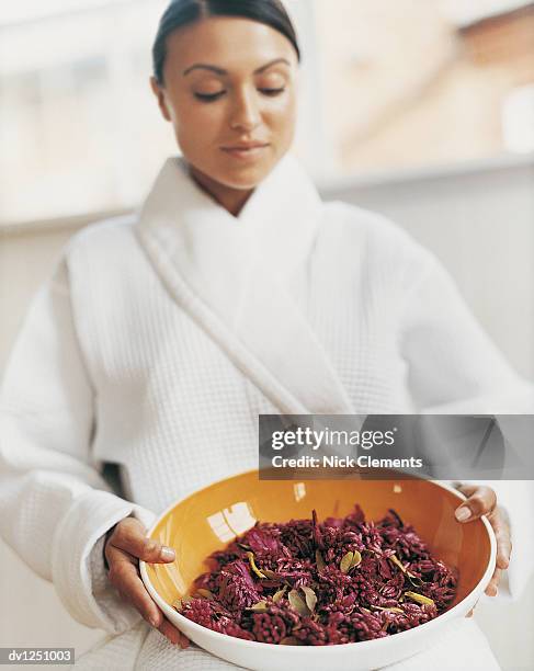 woman sitting in her dressing gown and holding a bowl of pot pourri - pot pourri ストックフォトと画像