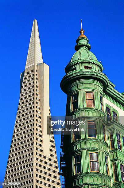 high section view of the transamerica pyramid side by side with an old fashioned building, san francisco, usa - transamerica-pyramid-san-francisco stock-fotos und bilder