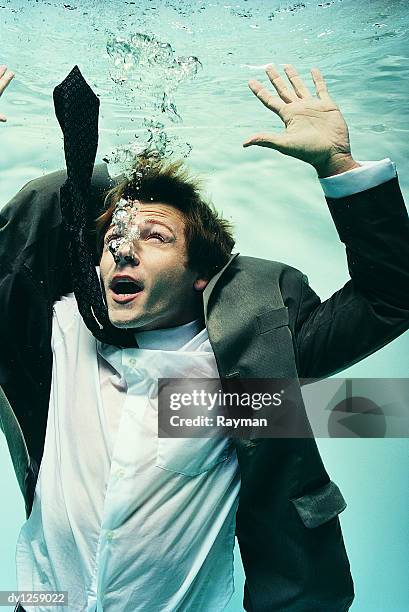 struggling businessman underwater - drowning foto e immagini stock