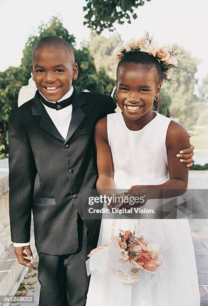 portrait of a page boy with his arm around a bridesmaid at a wedding - pageboy stock pictures, royalty-free photos & images