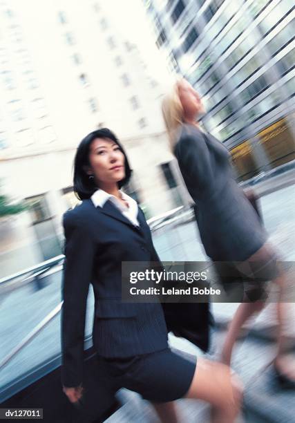 businesswomen walking up steps - leland bobbe foto e immagini stock