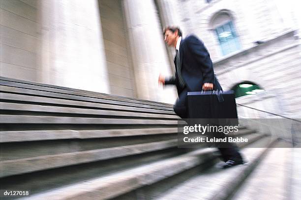 lawyer running up stairs of courthouse - leland bobbe foto e immagini stock