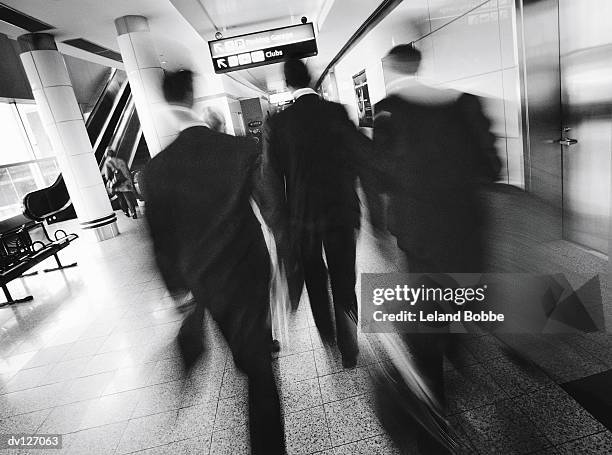 back of blurred businessmen walking in airport - leland bobbe foto e immagini stock