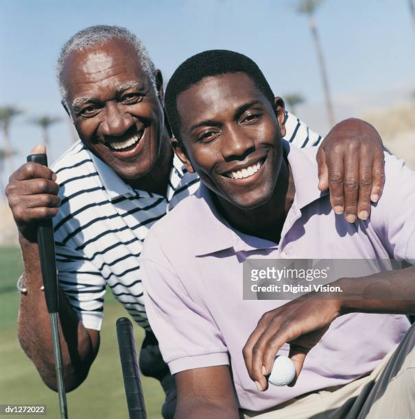 portrait of a father and son on a golf course - father son golf stock pictures, royalty-free photos & images