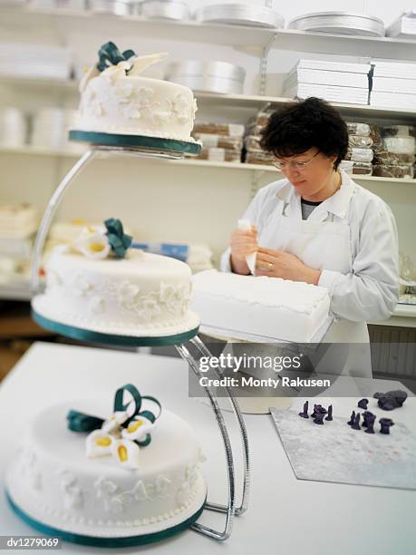 factory worker stands icing a wedding cake, grimsby, uk - wonky shelf stock pictures, royalty-free photos & images