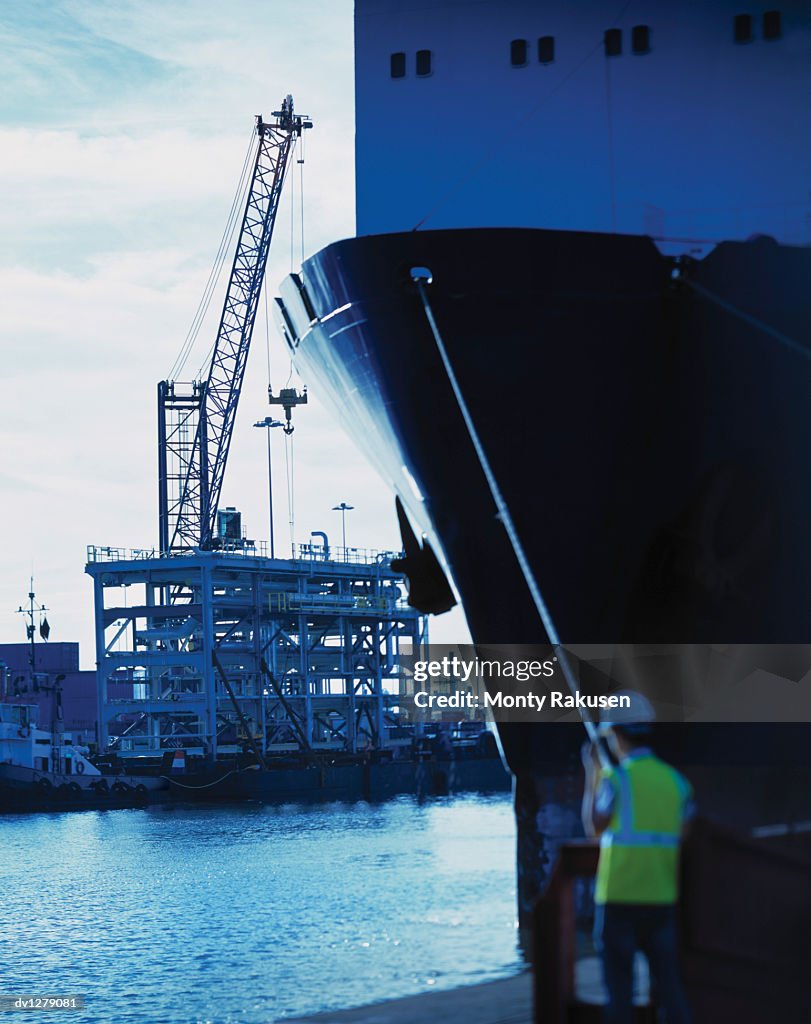 Man Stands By The Bow Of A Ship Watching Oil Rig Construction In ...
