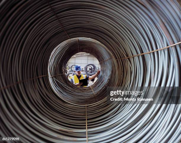 diminished perspective of a man checking steel wire for freight at immingham port, humberside, uk - immingham stock pictures, royalty-free photos & images