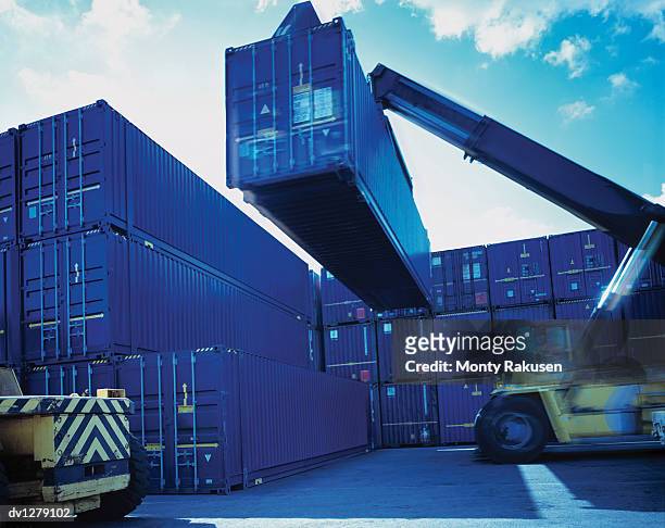 cherry picker lifting cargo container for freight transportation, immingham port, uk - immingham stock pictures, royalty-free photos & images