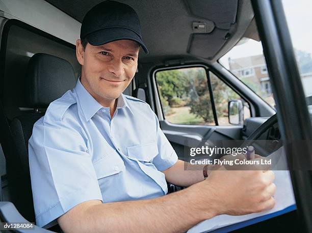 portrait of a driver writing on an invoice and sitting in the front seat of a delivery van - reliance industries ltd stock pictures, royalty-free photos & images