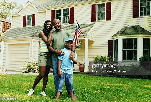 portrait of a family standing on a lawn in front of their home - american flag on stand stock pictures, royalty-free photos & images