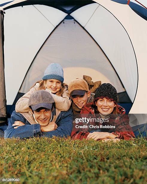 family of four in a tent, children lying on top of parents - happy tween girls lying on grass stock pictures, royalty-free photos & images