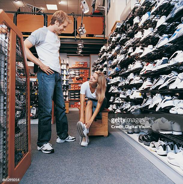 two young people in a shoe shop - calzature sportive foto e immagini stock