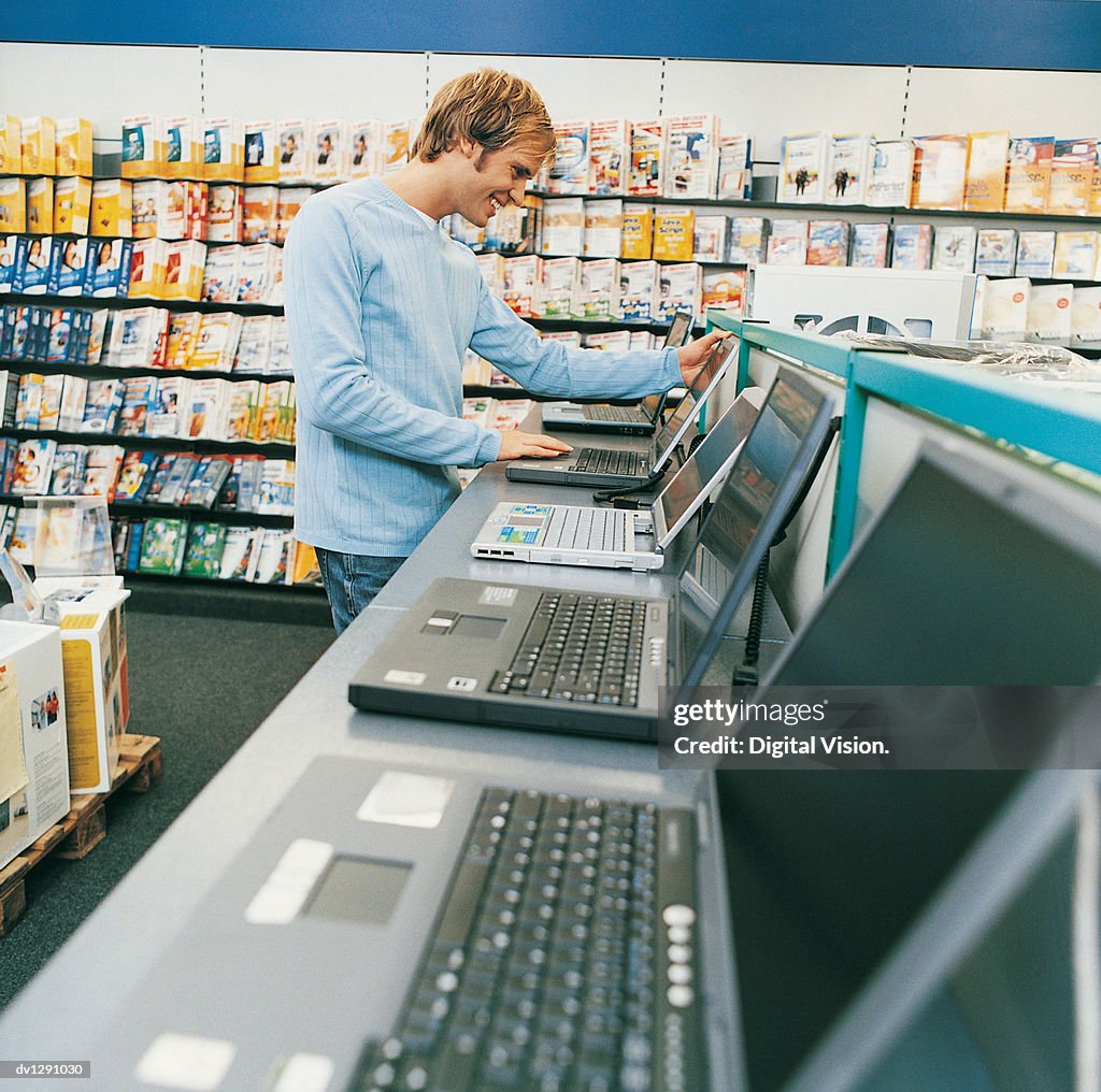 Computer Shop User Young Man Looking At A Laptop In A Computer Shop High-Res Stock Photo ...
