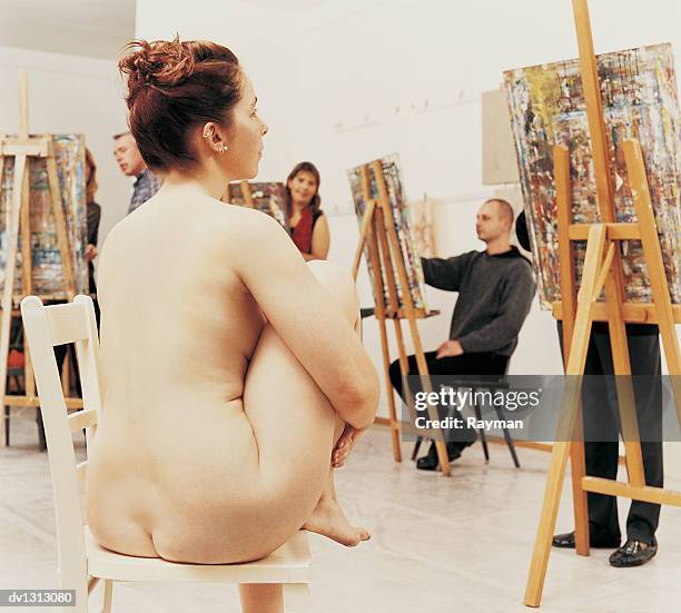 nude female model posing in a studio to art students - artists model stock photos et images de collection