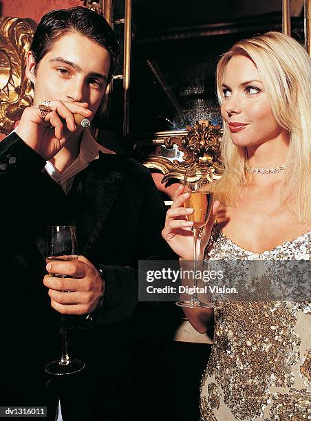 a couple drinking champagne and smoking a cigar - beautiful women smoking cigars fotografías e imágenes de stock