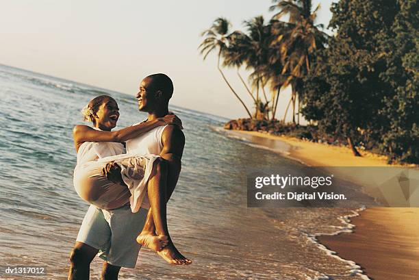 man carrying a woman on a paradise beach - paradise bildbanksfoton och bilder