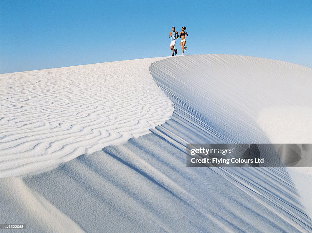 Couple Jogging on a Sand Dune