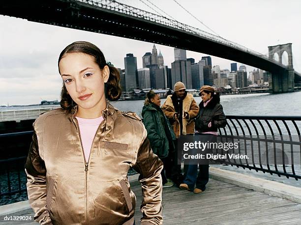 teenage girl standing apart from group under manhattan bridge in new york - manhattan foto e immagini stock