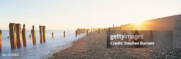 pebble beach at sunset, winchelsea, east sussex, united kingdom - east beach stock pictures, royalty-free photos & images