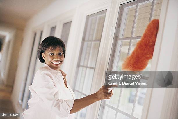 woman dusting windows of domestic interior - wonky fringe stock pictures, royalty-free photos & images
