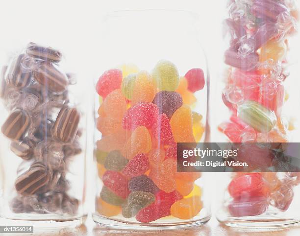 jars of sweets in a line - candy jar stock pictures, royalty-free photos & images