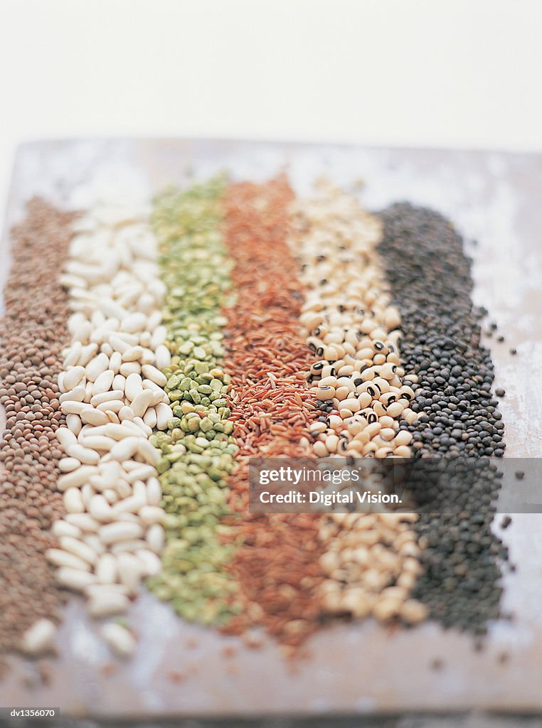 Beans and Lentils Arranged in Lines on a Chopping Board