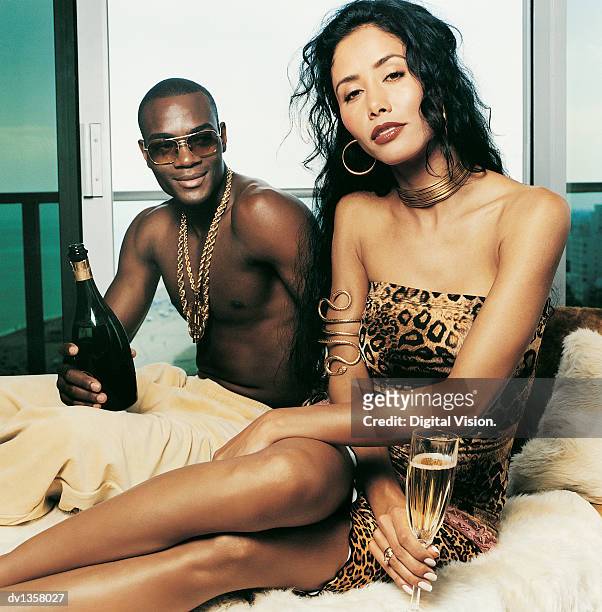 portrait of a couple sitting on a fur rug with champagne - societetsskönhet bildbanksfoton och bilder
