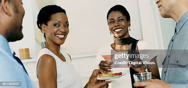 two women listening to a conversation standing at a party - listening party imagens e fotografias de stock