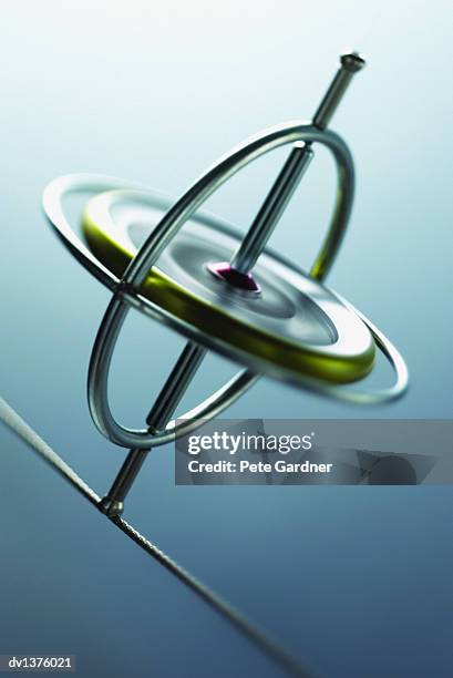 spinning gyroscope balancing on string - gyroscope stock pictures, royalty-free photos & images