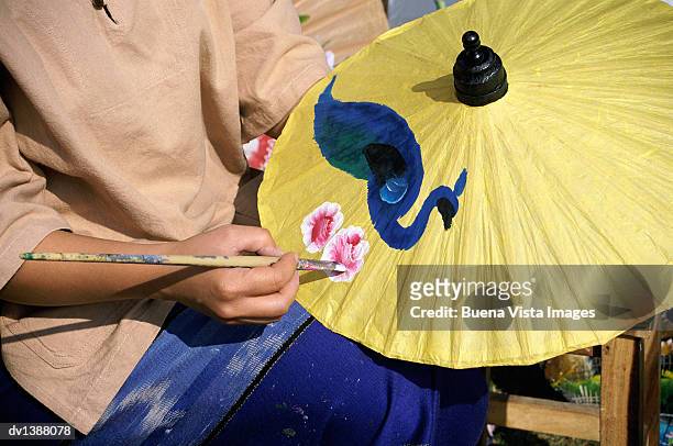 mid section of a person painting a sa paper umbrella, chiang mai, thailand - mai stockfoto's en -beelden