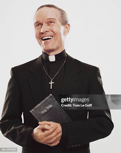 priest standing holding bible with joy - nun habit stock pictures, royalty-free photos & images