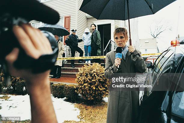 cameraman filming a tv reporter on a driveway at a crime scene - tv journalists stock pictures, royalty-free photos & images