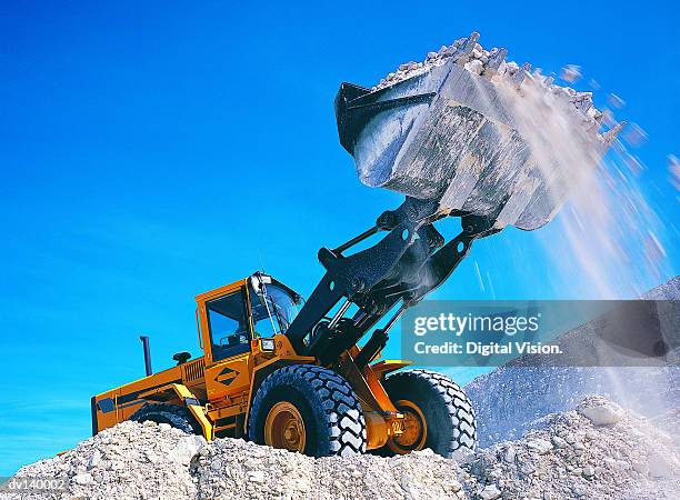 backhoe lifting rubble - construction vehicle stock pictures, royalty-free photos & images