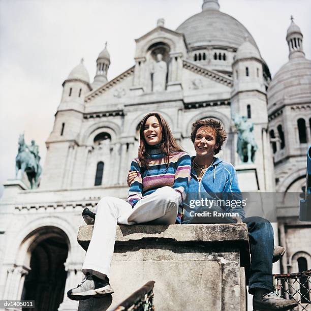 young tourist couple sitting in front of the sacre coeur basilica, paris, france - coeur stock pictures, royalty-free photos & images