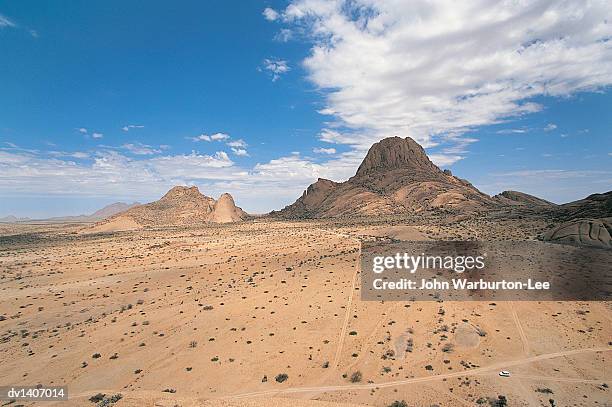 spitzkoppe rock formation scaled to vehicle in foreground, namibia - spitzkoppe stock pictures, royalty-free photos & images