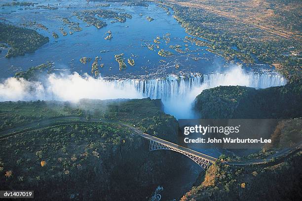 victoria falls and suspension bridge over zambesi river at dusk, shot from a microlite - warburton stock pictures, royalty-free photos & images