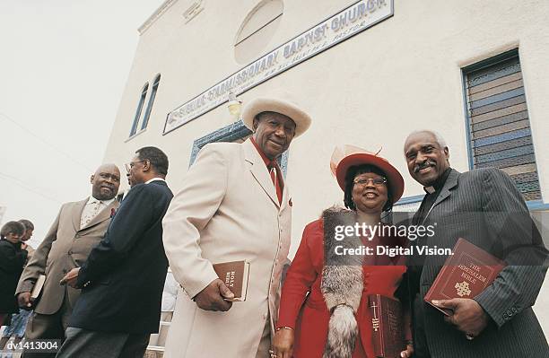 portrait of a priest with a group of people standing outside a church - godsdienstvrijheid stockfoto's en -beelden