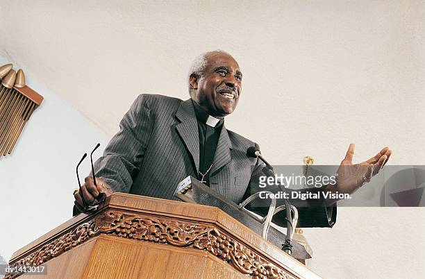 low angle view of a priest preaching from a church pulpit during a service - preacher stock pictures, royalty-free photos & images