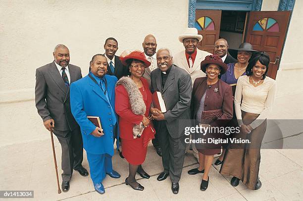 portrait of a group of men and women standing outside a church with a vicar - godsdienstvrijheid stockfoto's en -beelden