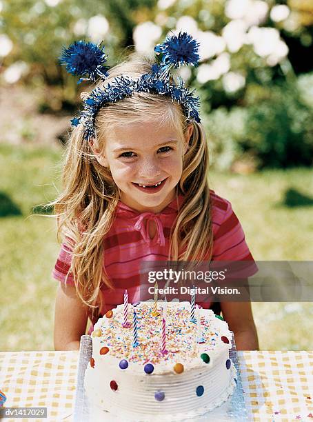 girl sitting at a table with her birthday cake - haarreifen mit sternchen stock-fotos und bilder