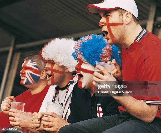 four english supporters in a line holding pint glasses of lager cheering from the stands - stadium stands fotografías e imágenes de stock