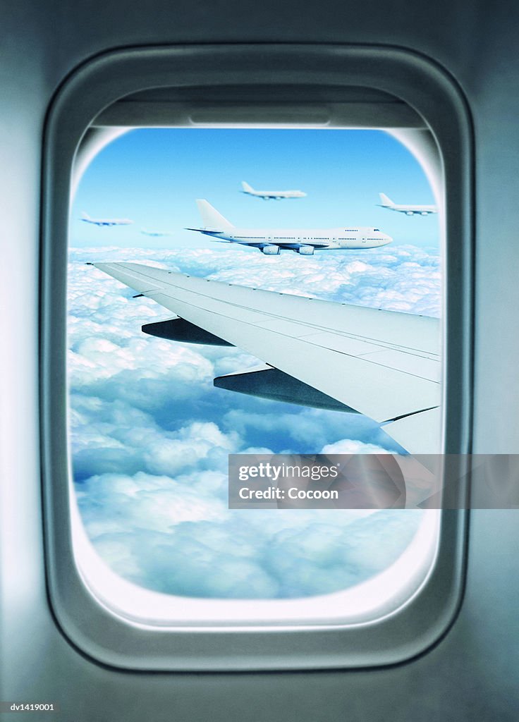 View of a Wing and Commerical Aircraft Out of a Plane Window