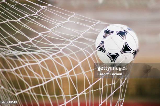 football trapped in a goal net, close-up - ball photos et images de collection