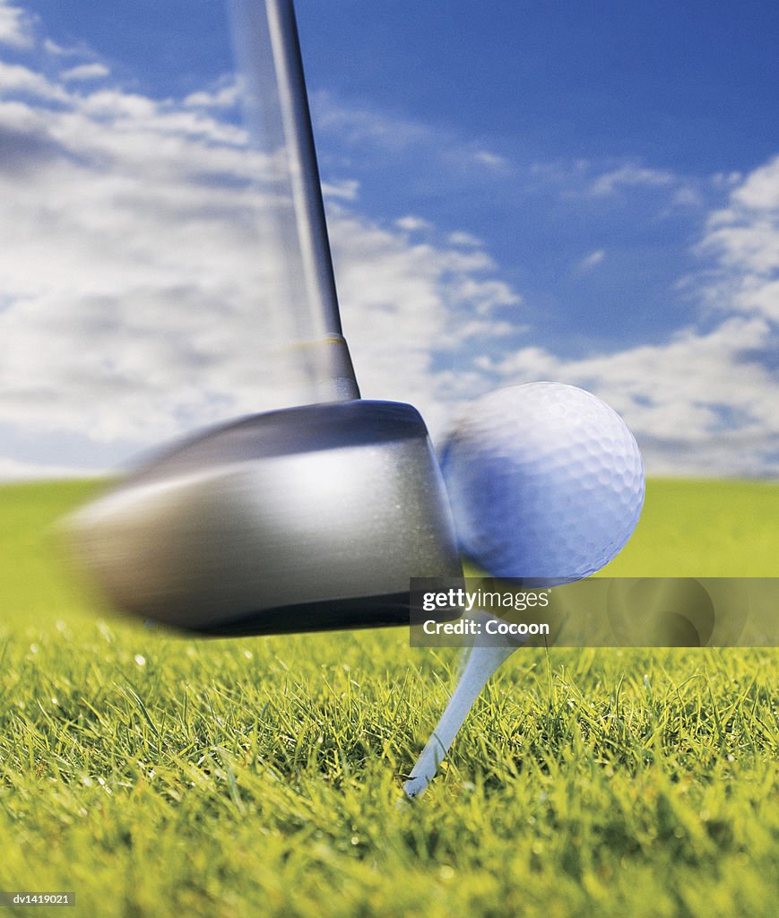 Close-Up of a Golf Club Hitting a Golf Ball Off the Tee
