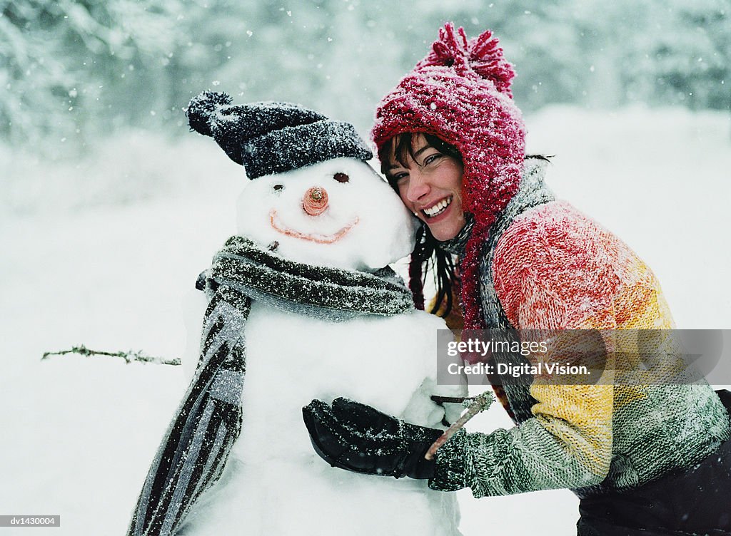Portrait of a Young Woman in the Snow Next to a Snowman