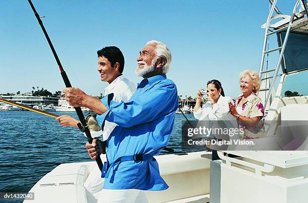 two men fishing at the stern of a boat as a woman photographs them - fischer boot stock-fotos und bilder