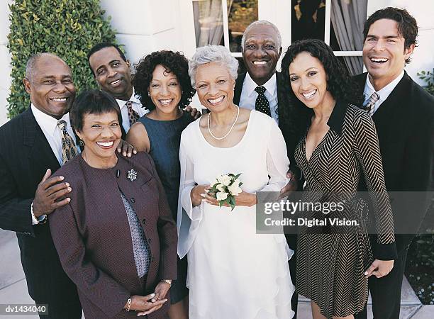 friends and family stand with a mature married couple at their wedding reception - mother and daughter smoking stock-fotos und bilder