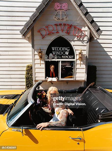 young newlywed couple sitting in a yellow convertible car in a drive-in chapel, nevada, usa - las vegas wedding stock pictures, royalty-free photos & images